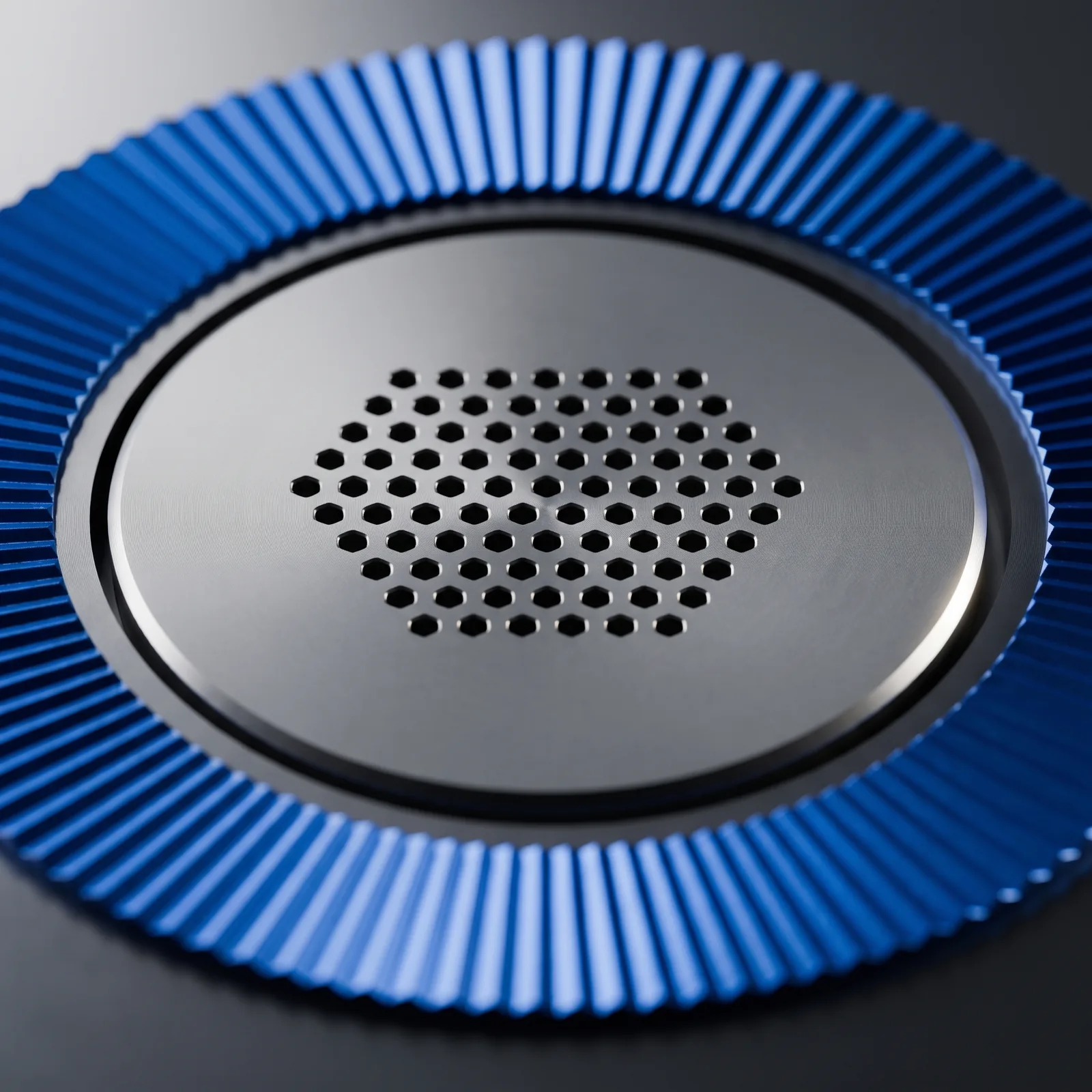 Macro of the perforated microphone crown inside the anodised dial ring.