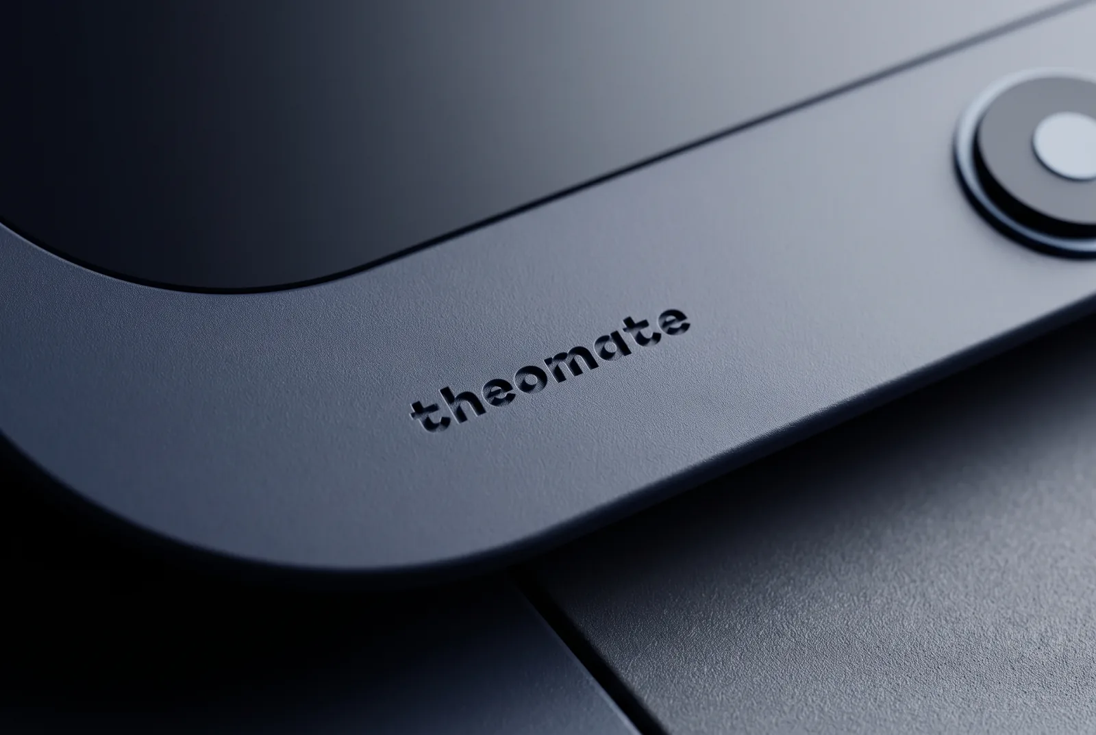 The theomate wordmark etched into the Midnight shell.